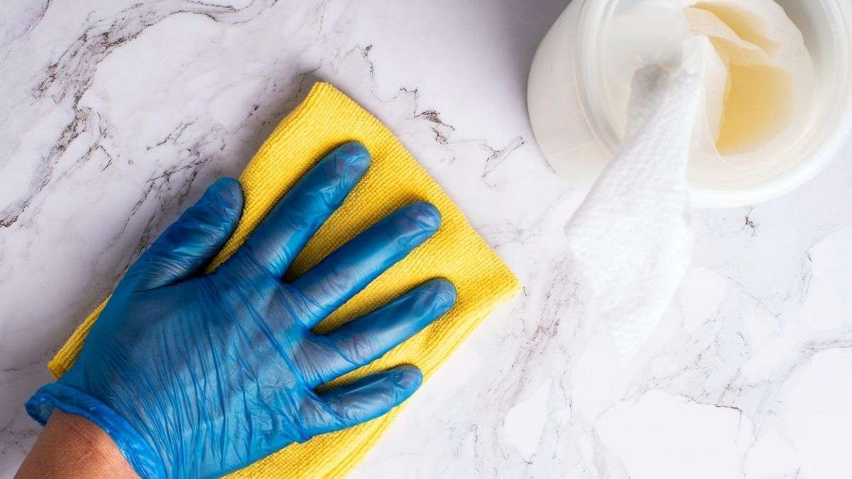 a hand in blue glove with a yellow cloth