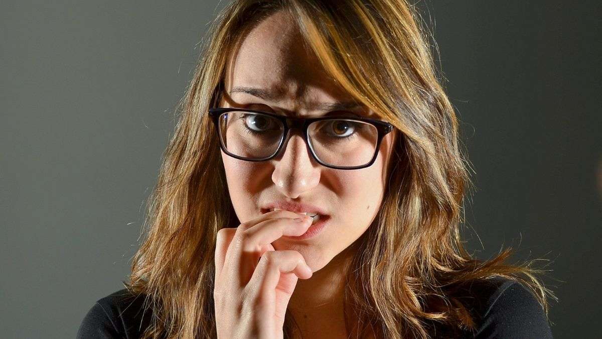 a woman with her finger in her mouth anxious about asking for prayer without giving details