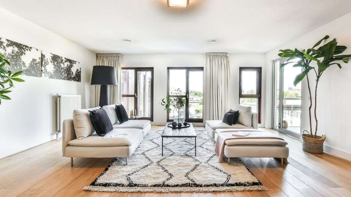 a living room with white couches and a rug - devotinal for settling into new home