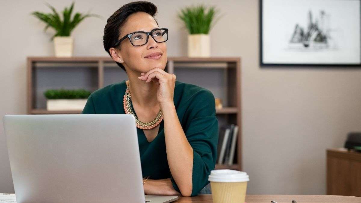 a woman sitting at a desk with a laptop and a cup of coffee how to pray for yourself