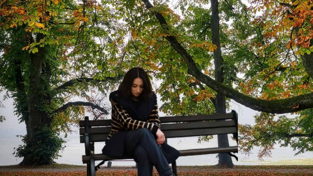 a woman sitting on a bench contemplating what does the Bible say about mental Health